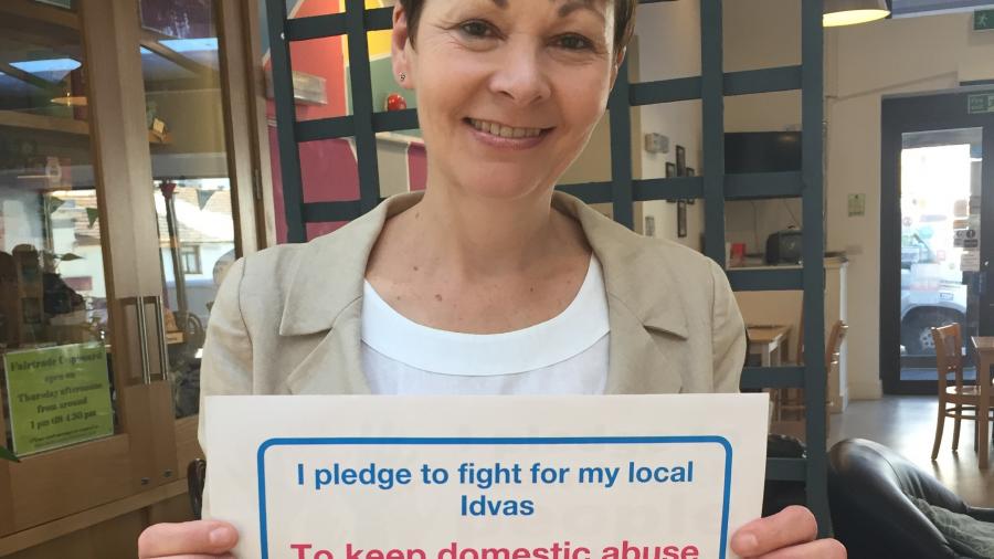 Caroline holding a pledge card in support of IDVAs