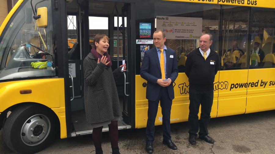 Caroline with Big Lemon staff standing next to the new solar bus